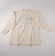 A cream-colored long-sleeve t-shirt with a small black circular graphic on the left chest reading Cold Brook Farm 2020 Oldwick, NJ, laid flat on a light gray background.